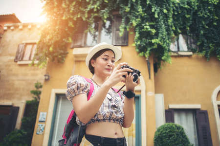 Portrait of young hipster woman backpack traveling taking photo in urban. Happy and enjoy with holiday.の写真素材