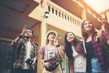 Group of happy young friends having fun walking in urban street. Friendship travel concept.の写真素材