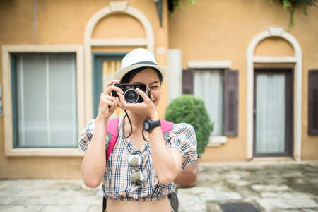 Close up of young hipster woman backpack traveling taking photo in urban.の写真素材