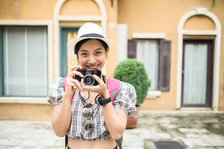 Close up of young hipster woman backpack traveling taking photo in urban.の写真素材