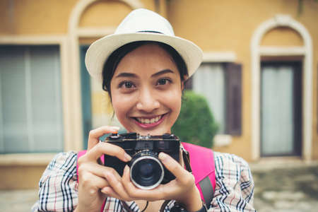 Close up of young hipster woman backpack traveling taking photo in urban.の写真素材