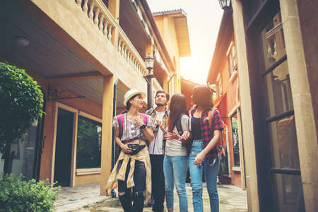 Group of happy young friends having fun walking in urban street. Friendship travel concept.の写真素材