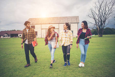 Group of student walking through the park after class. Enjoy talking together.の写真素材
