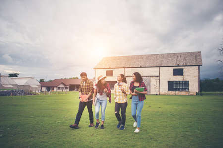 Group of student walking through the park after class. Enjoy talking together.の写真素材