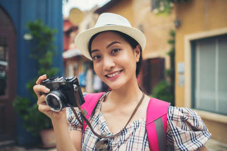 Close up of young hipster woman backpack traveling taking photo in urban.の写真素材