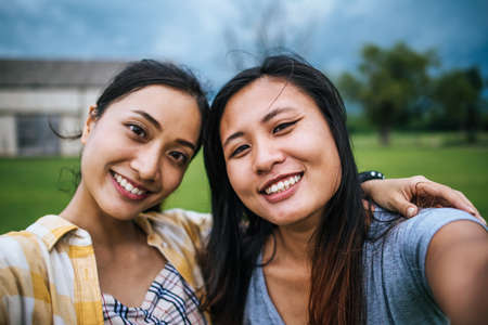Teen women friendship looking at camera make selfie.の写真素材
