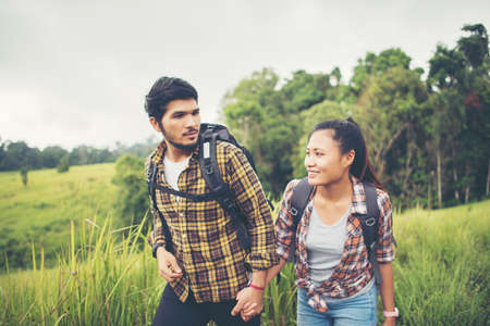 Portrait of happy young couple walking having fun on their hiking trip. Couple concept.の写真素材
