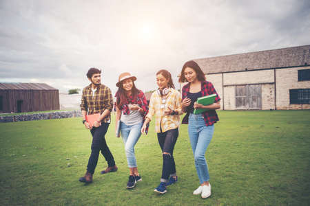 Group of student walking through the park after class. Enjoy talking together.の写真素材