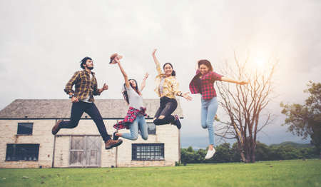 Happy group of teen student jumping in park