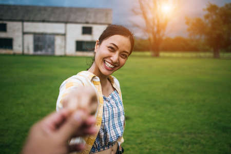 Woman walking on romantic happy holidays holding hand of boyfriend following herの写真素材