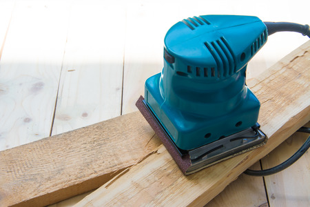 Carpenter with machine sanding for wood workerの写真素材