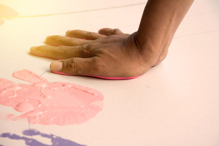 Hand make a trace colorful symbol on white paper backgroundの写真素材