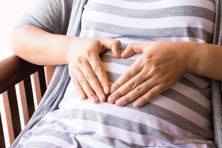 mother pregnant with clock on white backgroundの写真素材
