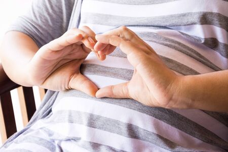 mother pregnant with clock on white backgroundの写真素材