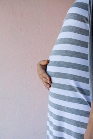 mother pregnant with clock on white backgroundの写真素材