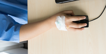 Woman patients on the bed have injection saline and working during in hospitalの写真素材