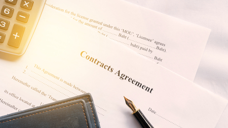 contract agreement document for sign with pen under orange worm shadeの写真素材