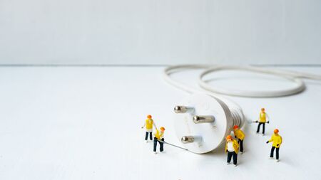 miniature electronic technician working to connect electricityの写真素材