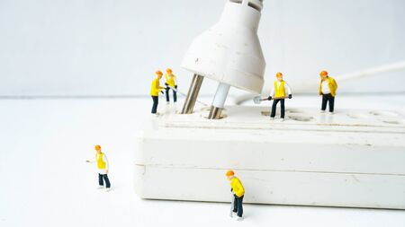 miniature electronic technician working to connect electricity