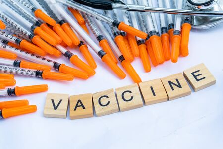 vaccine keyword on wood block with syringe and stethoscope