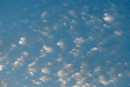 Blue sky with little orange cloudsの写真素材