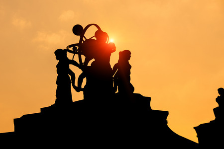 silhouette of a statue and gold skyの写真素材