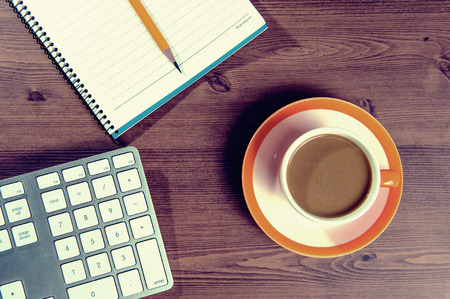 Cup of coffee and notebook on a wooden with vintage colour.の写真素材