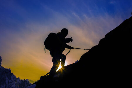 Silhouette of mountaineer and sunset.の写真素材