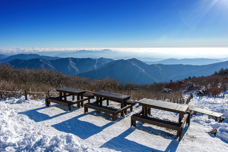 Wooden picnic tables with benches in winter,Deogyusan Mountains, South Korea.の写真素材