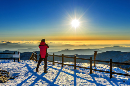 Mountaineer stands on the peak in Winter,Deogyusan national park in South Korea and watching to Sunrise. Beautiful moment the miracle of nature.の写真素材