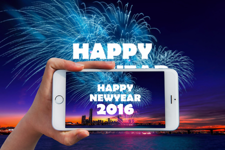 Hand holding smart phone take a photo at happy new year 2016 and Firework dishplay.の写真素材