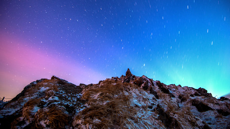 Star trails over the winter mountains landscape.の写真素材