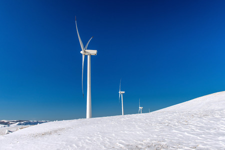 Wind turbine and blue sky in winter landscape.の写真素材