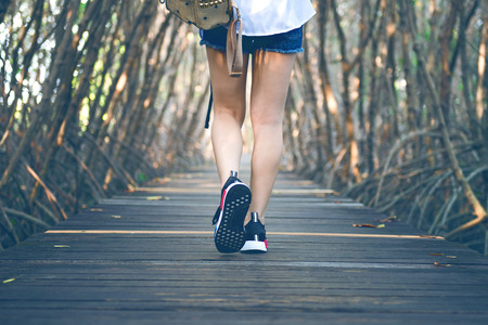 Woman walking on wooden bridge. Vintage tone.の写真素材