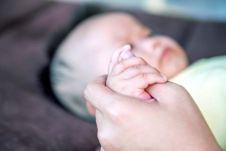 Baby hand holding mother's hands.の写真素材