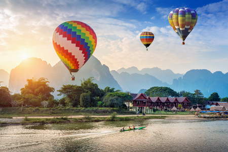 Hot air balloon over Nam Song river at sunset in Vang vieng, Laos.の写真素材