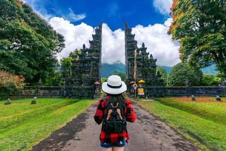 Woman traveler with backpack walking at Big entrance gate in Bali, Indonesia.の写真素材