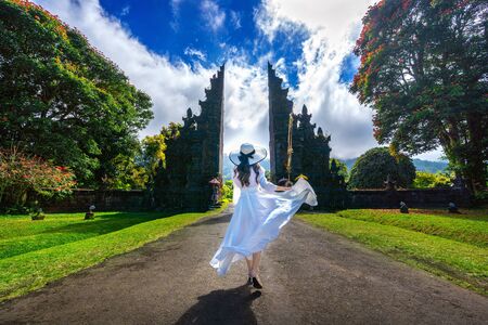 Woman walking at big entrance gate, Bali in Indonesia.の写真素材