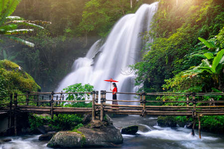 Asian woman wearing Thai dress costume traditional according Thai culture at Pha dok siew waterfall in Chiang Mai Thailand.の写真素材