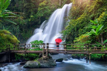 Asian woman wearing Thai dress costume traditional according Thai culture at Pha dok siew waterfall in Chiang Mai Thailand.の写真素材