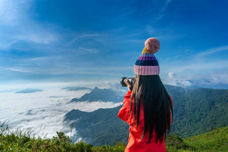 Tourist taking photographs with digital camera in a mountains. Phu chi fa mountains in Chiang Rai, Thailand.の写真素材