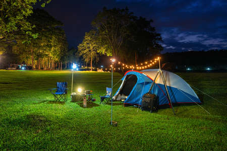 Camping tent and outdoor kitchen equipment at night in the park.の写真素材