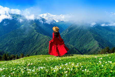 Tourist enjoy view of green pasture and flowers near snow mountain in Georgia.の写真素材