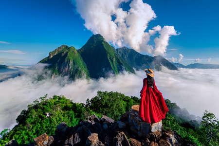 Tourist standing on Pha Dang viewpoint at sunrise in Muang Ngoy, Laos.の写真素材