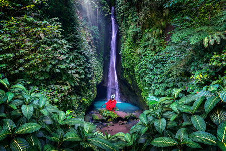 Tourist standing at Leke Leke waterfall in Bali, Indonesia.の写真素材