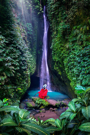 Tourist standing at Leke Leke waterfall in Bali, Indonesia.の写真素材