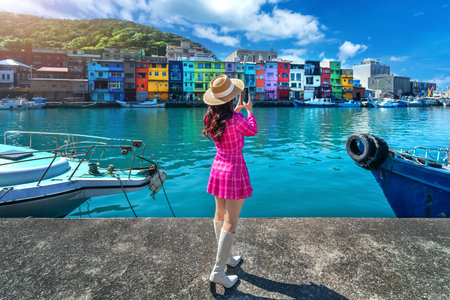 Tourist taking a photo at Colorful Zhengbin Fishing Port in Keelung, Taiwan.の写真素材
