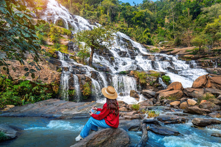 Tourist taking a photo and enjoy nature landscape at Mae ya waterfall, Chiang mai.の写真素材