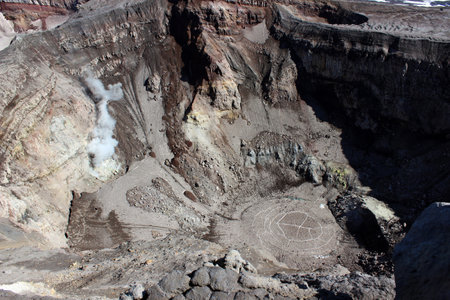 Active crater of Gorely volcano with a dried up, covered with ice lake and fuming fumarole, Kamchatka Peninsula, Far Earst Russiaの写真素材