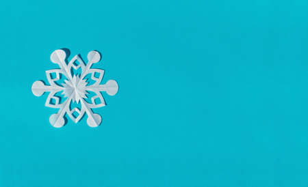Handmade paper snowflake on blue background, top view, flat lay, copy space
